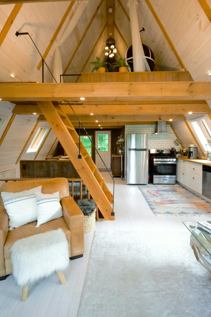 beautiful a-frame style home with a clean and bright environment and a wooden staircase that leads up to a loft.